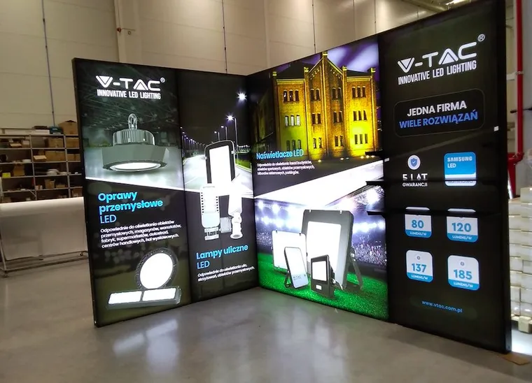 Stoisko V-TAC w kształcie L z podświetlanymi grafikami opraw przemysłowych, lamp ulicznych i naświetlaczy