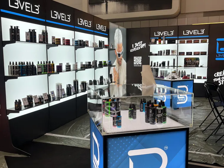 Ściana L3VEL3 z produktami na podświetlanych półkach i kostka z witryną z plexi, dzień przed otwarciem targów